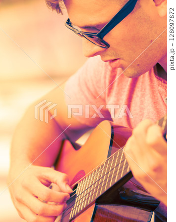 Trendy guy with guitar outdoor Trendy guy with guitar outdoor 128097872