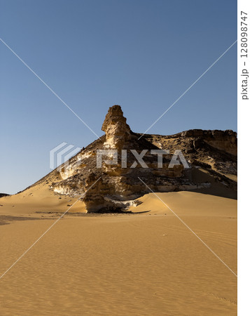 Ash-covered hills in Egypt's Black Desert under a clear sky, scenic and remote landscape. Volcanic Ash-covered hills in Egypt's Black Desert under a clear sky, scenic and remote landscape. Volcanic 128098747