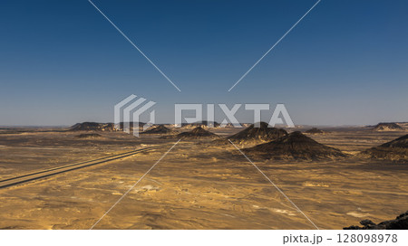 Ash-covered hills in Egypt's Black Desert under a clear sky, scenic and remote landscape. Volcanic	 128098978