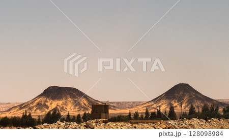 Ash-covered hills in Egypt's Black Desert under a clear sky, scenic and remote landscape. Volcanic	 128098984