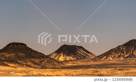 Ash-covered hills in Egypt's Black Desert under a clear sky, scenic and remote landscape. Volcanic	 128098986