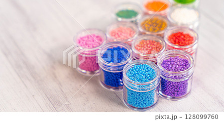 Colorful glass beads. Variety of shapes and colors to make a bead necklace or a string of beads for women 128099760