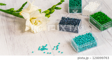 Colorful glass beads with flowers. Variety of shapes and colors to make a bead necklace or a string of beads for women 128099763