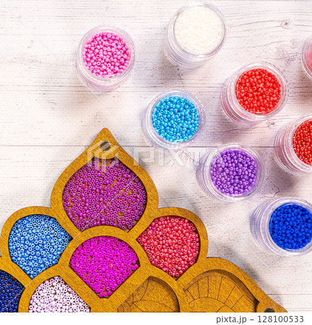 Colorful glass beads. Variety of shapes and colors to make a bead necklace or a string of beads for women 128100533