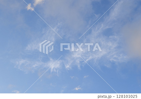 Light wispy cloud formations scattered over vibrant blue sky for clean sky background Light wispy cloud formations scattered over vibrant blue sky for clean sky background 128101025