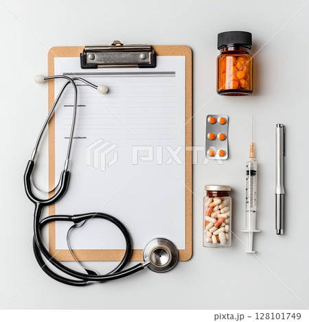 Medical arrangement featuring a stethoscope, clipboard, pills, and a syringe, hinting at health and wellness. 128101749