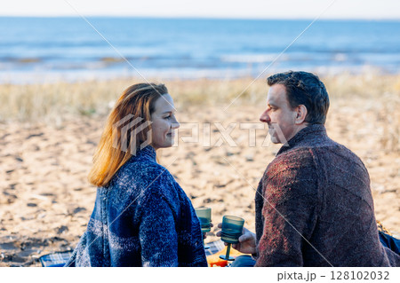 Portrait happy beautiful couple in love enjoying autumn picnic in autumn park. Back view. High quality photo 128102032