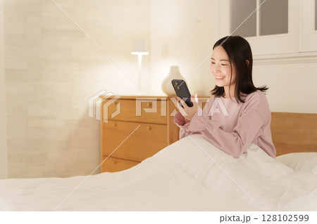 夜中にスマホを見る女性 夜中にスマホを見る女性 128102599