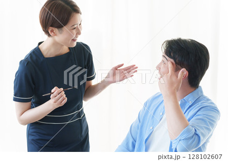 美容部員に眉毛のメイクをしてもらう男性 128102607