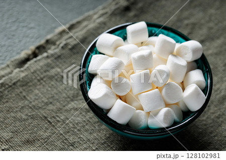 Tasty Marshmallow Snack in Turquoise Bowl with Green Background Tasty Marshmallow Snack in Turquoise Bowl with Green Background 128102981