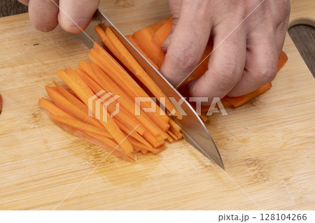 キッチンできんぴらごぼうを作る工程　人参を千切りにする 128104266