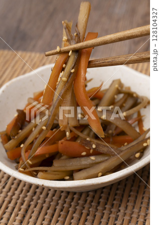小鉢に盛り付けたきんぴらごぼうを箸で持ち上げる 128104327