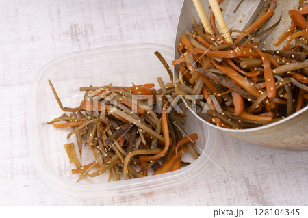 作り置きのきんぴらごぼうを保存容器に移す 128104345