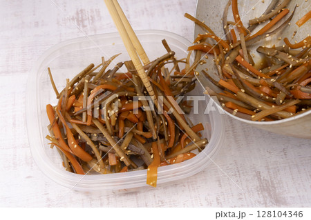 作り置きのきんぴらごぼうを保存容器に移す 128104346