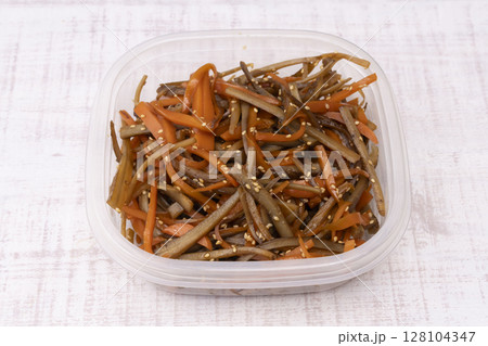 作り置きのきんぴらごぼうを保存容器に移す 128104347