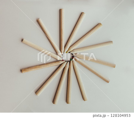 Group of brown crayons arranged in a circle on silver background. 128104953