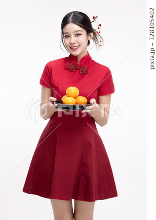 Portrait of joyful beauty Asian woman in red Cheongsam Chinese traditional dress celebrating with lucky fresh oranges on Chinese New Year festival isolated on white background. Portrait of joyful beauty Asian woman in red Cheongsam Chinese traditional dress celebrating with lucky fresh oranges on Chinese New Year festival isolated on white background. 128105402