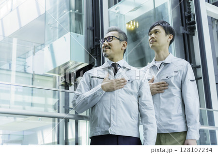 オフィスビルの中に立つ胸に手を当てる2人の作業員 撮影協力:スカパー東京メディアセンター オフィスビルの中に立つ胸に手を当てる2人の作業員 撮影協力:スカパー東京メディアセンター 128107234