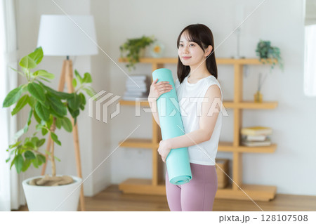 リビングでヨガをする若い女性 リビングでヨガをする若い女性 128107508
