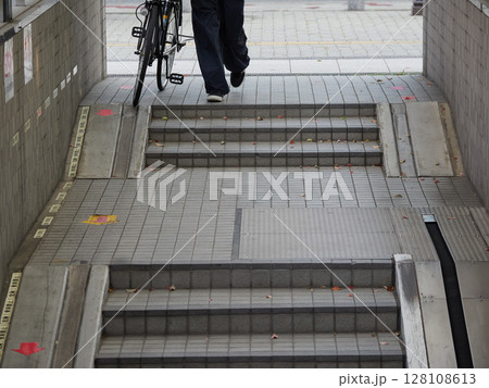 街の駅前の地下駐輪場の入り口と若者の姿 128108613