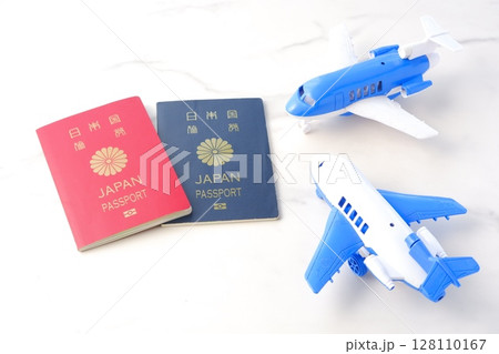 日本のパスポート（10年用赤色と5年用紺色）と飛行機で、長期休暇に海外旅行を計画しているイメージ 128110167