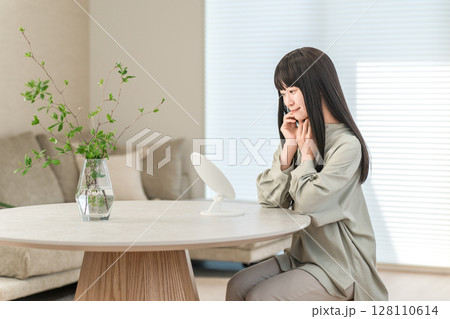部屋で鏡を見ながらスキンケア,スキンチェックする若い女性 部屋で鏡を見ながらスキンケア,スキンチェックする若い女性 128110614