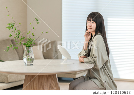 部屋で鏡を見ながらスキンケア,スキンチェックする若い女性 部屋で鏡を見ながらスキンケア,スキンチェックする若い女性 128110618