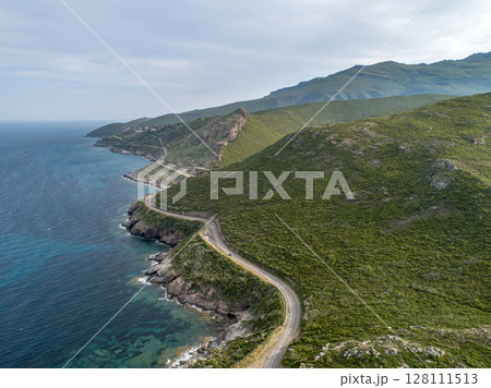 Aerial view car Roadtrip Winding road along rocky coast of Cap Corse peninsula on Corsica island France Aerial view car Roadtrip Winding road along rocky coast of Cap Corse peninsula on Corsica island France 128111513