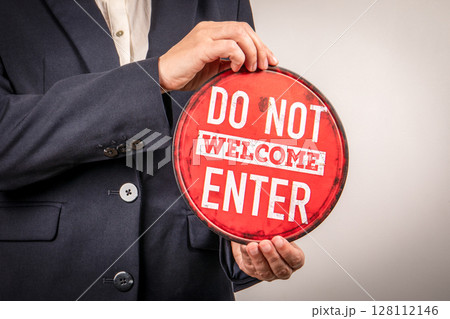 Rejection or Exclusion Concept with Do Not Welcome Sign Held by Businessperson 128112146