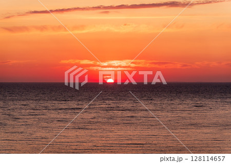 Beautiful red and orange sunrise over the sea. Beautiful red and orange sunrise over the sea. 128114657