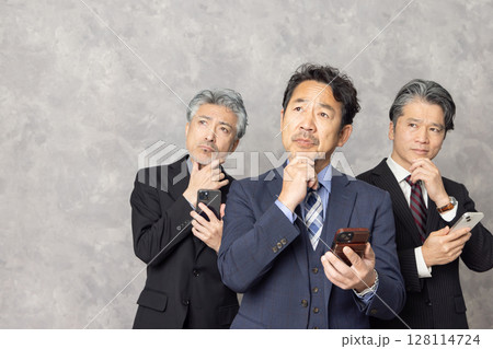 スマートフォンで検索するミドルエイジ男性ビジネスパーソン 128114724