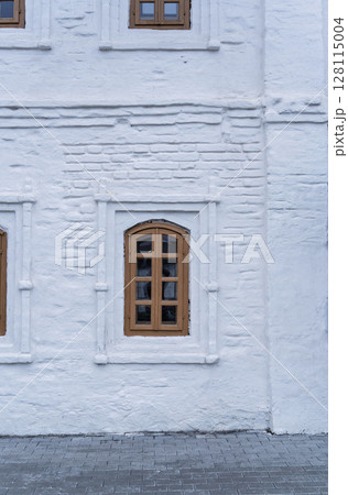 Window of the old 17 century building. Old stone wall with window 128115004