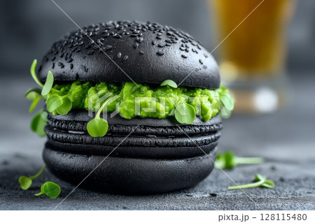 A vegan burger that is green and delicious, topped with microgreens, oil, and black pepper, is set against a white background 128115480