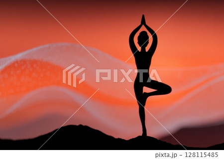 The image of a female hiker standing by a large stone at sunset in the mountains represents the concepts of tourism, travel, and healthy living 128115485