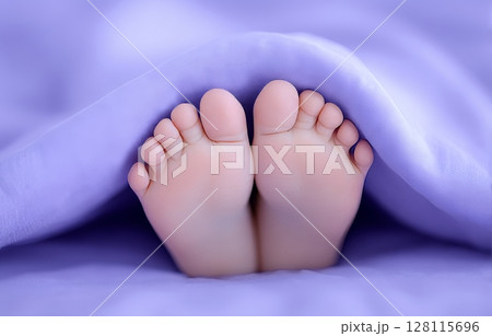 A baby girl's feet are wrapped in a pastel pink blanket in this closeup shot 128115696