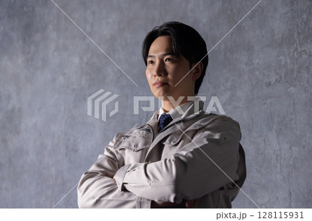 黒壁の前で腕組みをして見上げる作業服の男性 黒壁の前で腕組みをして見上げる作業服の男性 128115931