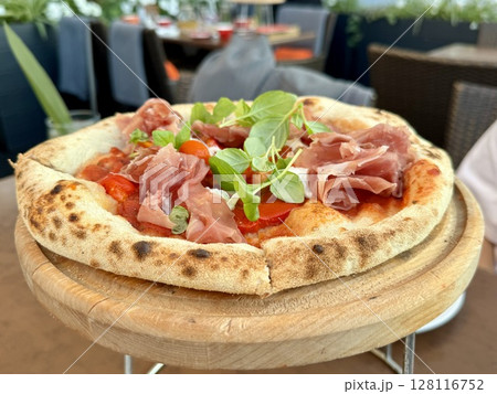 delicious juicy pizza in a cafe on a table. High quality photo 128116752