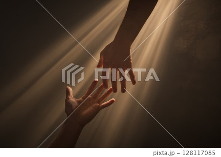 Two Hands Barely Touching in a Beam of Light, Symbolizing Connection and Hope 128117085