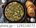 An omelette filled with herbs, chives, and oregano, and topped with another omelette that has chili flakes 128118272