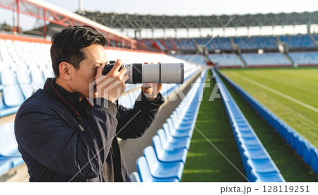 競技場で望遠カメラを構える男性 128119251