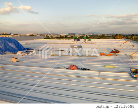 Metal roof sheet installation or construction for factory warehouse. 128119589