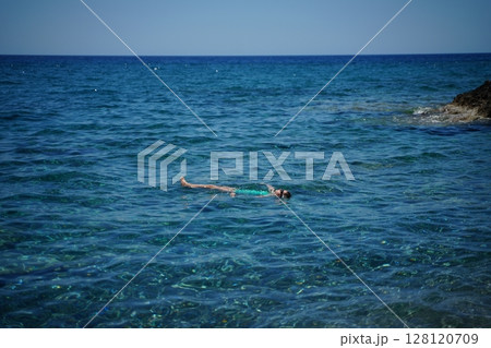 Relaxing Solo Floating in Tranquil Ocean Waters 128120709