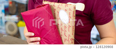 Delivery mail post postal packages red and craft paper in hands 128120908