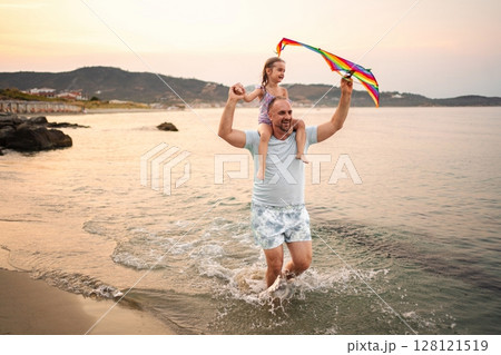 Joyful family moment at the beach during sunset by the shore Joyful family moment at the beach during sunset by the shore 128121519