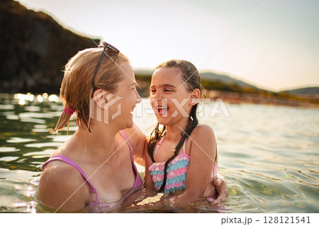 Joyful moments between mother and daughter at a sunny beach 128121541