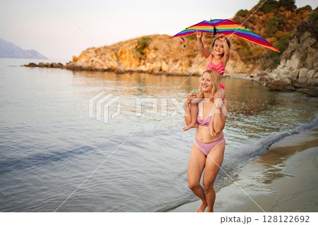 Joyful family fun at the beach during a sunny summer evening 128122692