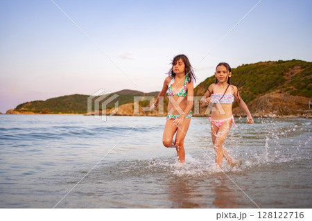 Joyful family moments at the beach on a sunny afternoon 128122716