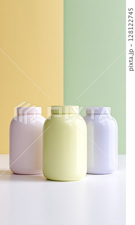 Three identical jars in pastel colors are arranged on a clean surface against a backdrop of soft yellow and green walls, providing a modern aesthetic Three identical jars in pastel colors are arranged on a clean surface against a backdrop of soft yellow and green walls, providing a modern aesthetic 128122745