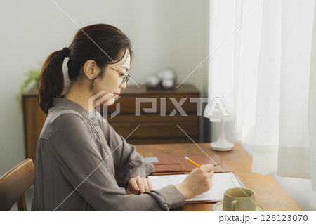 自宅でデスクに向かう女性　 128123070