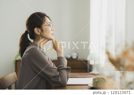 自宅でデスクに向かう女性 自宅でデスクに向かう女性 128123071